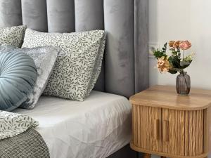 a bed with a vase of flowers on a table at Apartament 2 pokojowy z balkonem wysoki standard PREMIUM in Namysłów