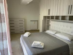 a bedroom with a large bed with towels on it at Beautiful Apartment with Swimming Pool in Olbia
