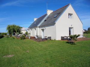 une maison blanche avec une pelouse devant elle dans l'établissement La Dunette, à Penmarcʼh