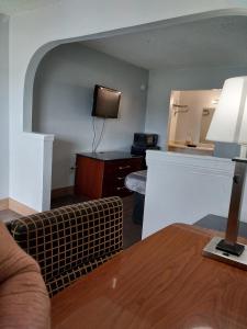 a living room with a couch and a tv at King Bed Hotel Suite 202 in Jackson