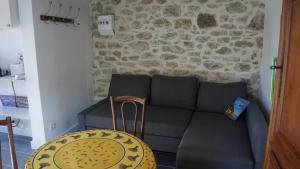 a living room with a black couch and a table at Votre terrasse vue mer sous la vigne, un havre de paix in Ensuès-la-Redonne