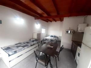 a room with two beds and a table and chairs at Monoambiente SAO in San Antonio Oeste +3 photos