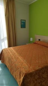 Montepaone LidoにあるVIDA B&B Ristorante Pizzeriaのベッドルーム1室(大型ベッド1台、オレンジ色の掛け布団付)