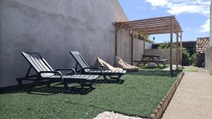 zwei Stühle auf dem Rasen neben einem Gebäude in der Unterkunft Casa das Hortas in Vila Franca do Campo