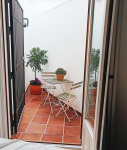 einen Balkon mit einem Tisch und Topfpflanzen in der Unterkunft Évoca Home in Córdoba