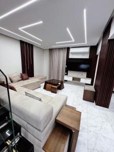 Una gran sala de estar con un sofá y una mesa. en Comfy 3-Bedrooms duplex Furnished Apartment in Cairo Sheraton airport, en El Cairo