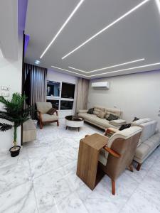 Una sala de estar con sofás y una mesa. en Comfy 3-Bedrooms duplex Furnished Apartment in Cairo Sheraton airport, en El Cairo
