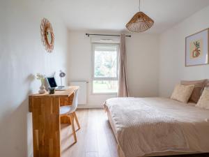 a bedroom with a bed and a desk with a computer at Le Cocon de Saint-Priest 1 Chambre Terrasse et Parking in Saint-Priest
