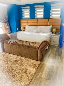 a large bed in a bedroom with a blue wall at Kliprivier Guest House in Tokoza