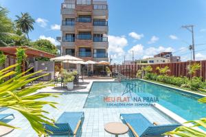 a swimming pool in front of a building at Paraíso familiar em frente a vila do pescador caboclo na nova orla de Tamandaré in Tamandaré
