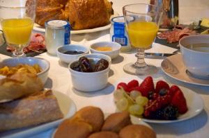ein Tisch mit Tellern voller Essen und Gläsern mit Orangensaft in der Unterkunft La Ruelle au Verjus in Sancé