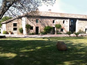 ein großes Steingebäude mit einem Rasenhof in der Unterkunft La Ruelle au Verjus in Sancé