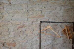 einem hölzernen Kleiderbügel vor einer Ziegelmauer in der Unterkunft La Ruelle au Verjus in Sancé