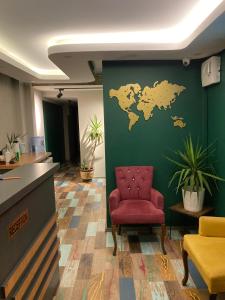 un bureau avec une carte du monde sur un mur vert dans l'établissement Vero Hotel, à Konak