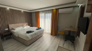 a hotel room with a bed and a television at Vero Hotel in Konak