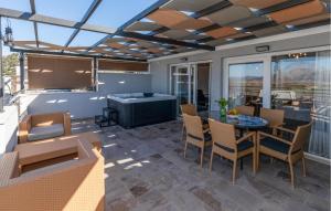 a screened in patio with a table and chairs at 3 Bedroom Awesome Home In Mliniste in Mlinište