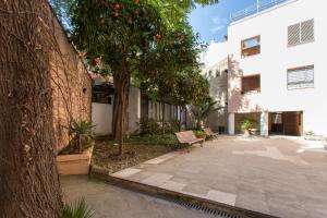 a courtyard with a tree and a bench next to a building at LR Parking incluido ubicacion central in Seville