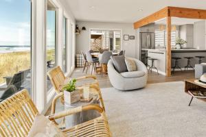 un soggiorno con sedie e tavolo e una cucina di Seas the Day. a Rockaway Beach