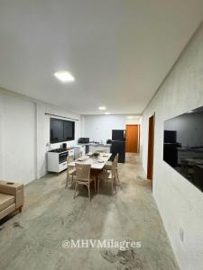 a room with a table and chairs and a kitchen at MHV Milagres - Casa Maria, Refugio em condomínio a poucos metros da paradisíaca praia do Marceneiro! in Passo de Camarajibe