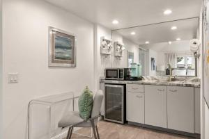 a white kitchen with a sink and a microwave at Chic La Jolla Studio Steps to Ocean & Dining in San Diego