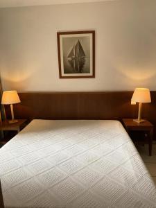 a bedroom with a bed with two lamps and a picture at Résidence Les Grands Pins - maeva Home - 2 Pièces 4 Personnes - Confort MAE-9923 in Maubuisson