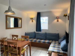 a living room with a couch and a table at Résidence Les Grands Pins - maeva Home - 2 Pièces 4 Personnes - Confort MAE-9923 in Maubuisson