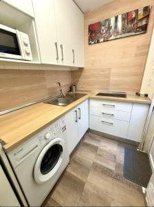 a kitchen with a washing machine and a sink at Apartamento Plaza de los naranjos in Marbella +7 photos