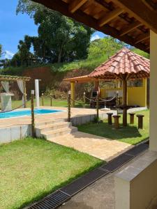a patio with a table and an umbrella next to a pool at Excelente casa com piscina próximo SP in Nazaré Paulista +14 photos