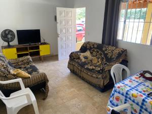a living room with a couch and a chair and a tv at Excelente casa com piscina próximo SP in Nazaré Paulista