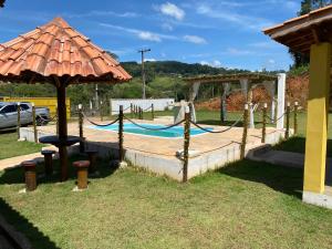 a playground with a hammock and an umbrella at Excelente casa com piscina próximo SP in Nazaré Paulista