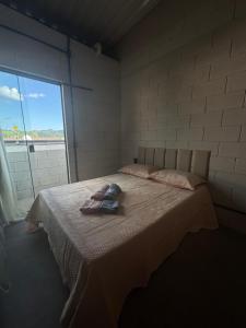 a bedroom with a bed with two towels on it at LOFT ROOTS rosa in Joanópolis