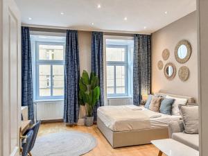 - un salon avec un lit et deux fenêtres dans l'établissement Augarten Suites I 5 min to Metro I 10 Min to City, à Vienne