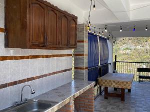 a kitchen with a sink and a table on a balcony at Terrazas Hotel and Hostel in Taxco de Alarcón