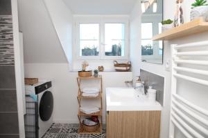 a small bathroom with a sink and a washing machine at L'Attique, confort, aéré, centre-ville, Netflix in Laval