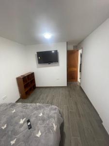 a bedroom with a bed and a flat screen tv at Increíble apartamento norte Tunja in Tunja