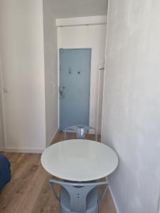 - une table blanche dans une chambre avec porte dans l'établissement Chambre privée - Vue Tour Eiffel, à Paris
