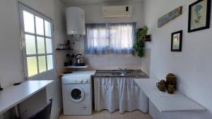 a kitchen with a washing machine and a sink at Jazmín del cielo Monoambiente independiente interno in Paraná +35 photos