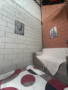 a bedroom with a brick wall with a bed in it at LOFT ROOTS rosa in Joanópolis +5 photos