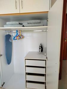 un armario con gabinetes blancos, lavabo y toallas. en Sunny Nest, en Esparta 22 fotos más