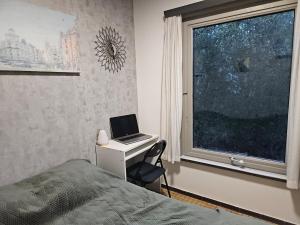 a bedroom with a bed and a desk with a laptop at Wali's Nature Bliss Dinant Givet in Waulsort