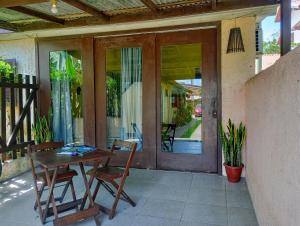 a patio with a table and chairs and a glass door at Hibisco Rosa Aluguéis in Araçatuba