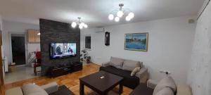 een woonkamer met een bank en een tv bij Villa Aida in Bihać