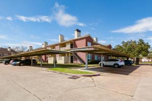 um prédio com carros estacionados em um estacionamento em Gated 2BR Townhouse, Pool & Patio, Near Museums em Houston
