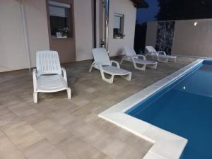 een groep stoelen naast een zwembad bij Villa Aida in Bihać