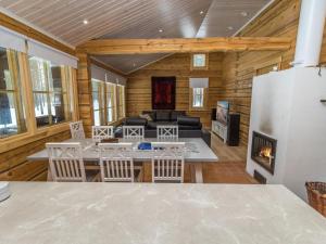 ein Wohnzimmer mit Kamin in einer Blockhütte in der Unterkunft Holiday Home Juohde by Interhome in Kuusamo
