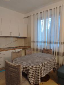 a kitchen with a table and chairs and a window at Asja's Apartment Vlore in Vlorë +14 photos