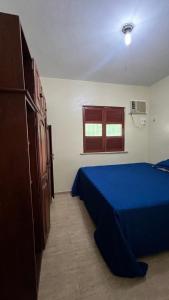 a bedroom with a blue bed and a window at Paraíso in Benfica