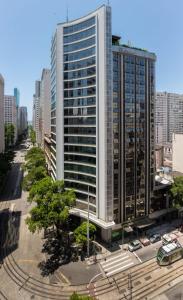 un edificio alto y blanco en medio de una ciudad en Residencial Casa Mauá - Conforto e Elegância, en Río de Janeiro