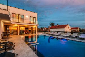 a swimming pool with chairs and a house at Villa Stressless in Smoković