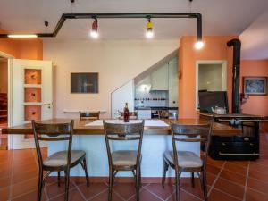 una cocina con una barra con 4 sillas alrededor en Holiday Home Cascina Calore by Interhome, en Cortiglione